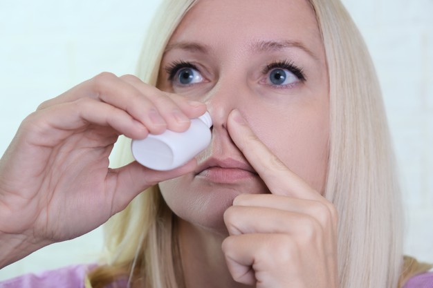 WOMAN WITH NASAL SPRAY